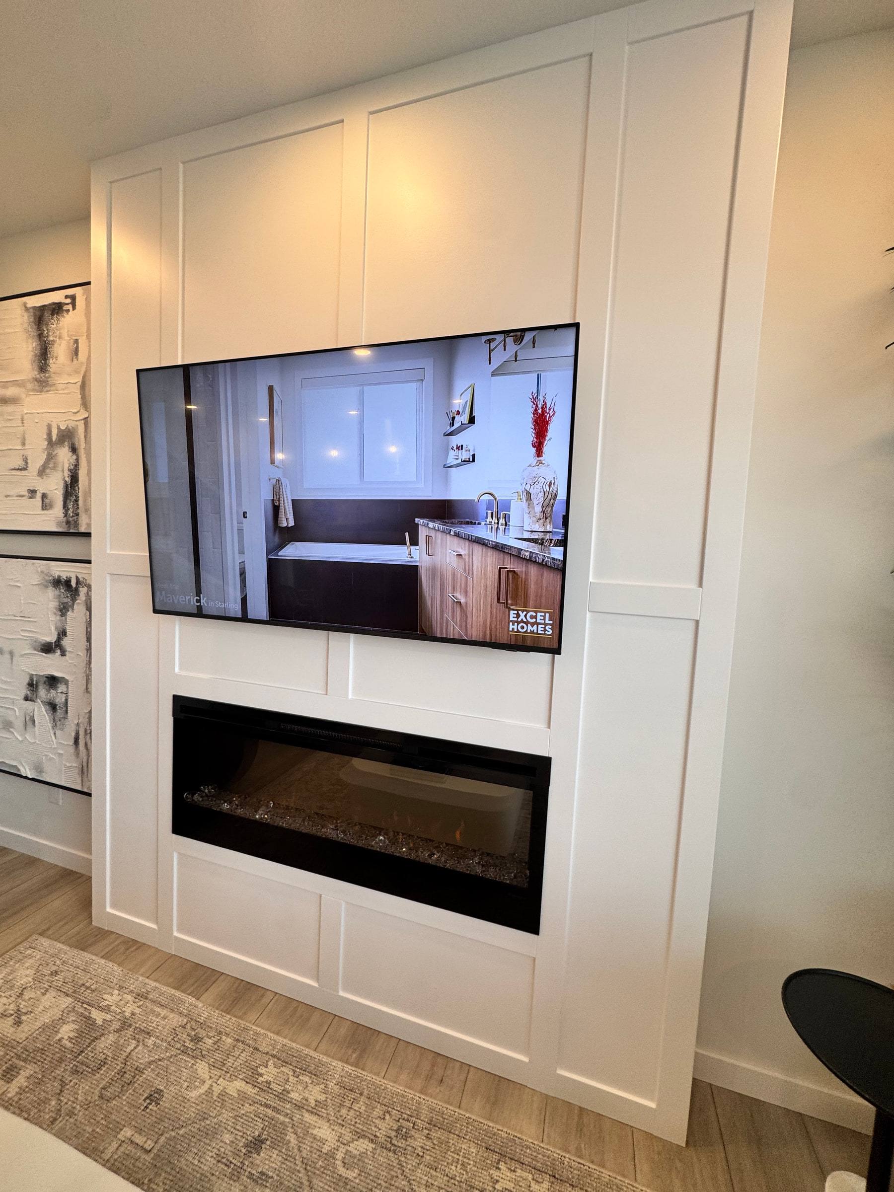 White panelled media wall with a recessed TV above a linear electric fireplace