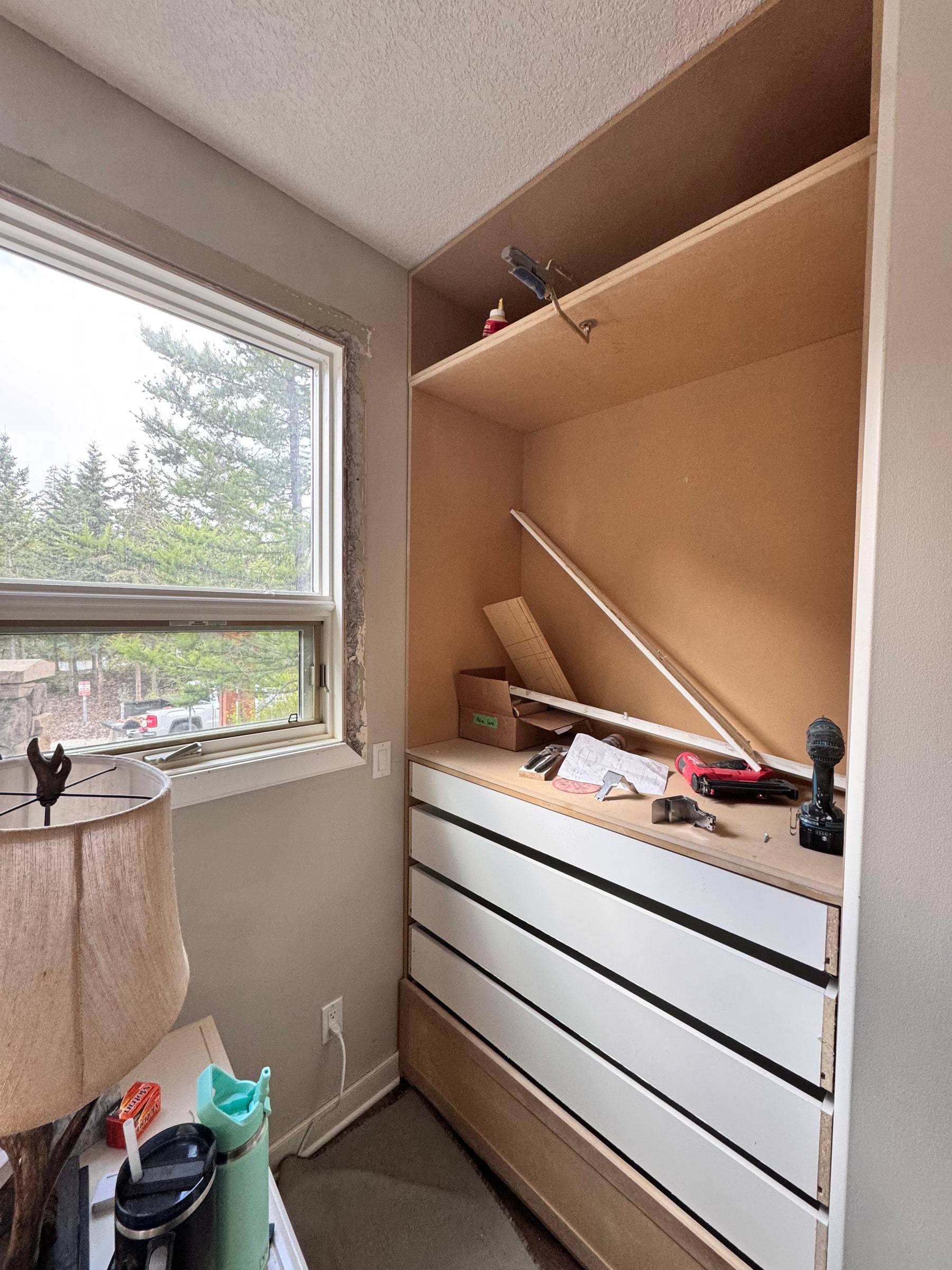 Wardrobe carcass during installation with drawer boxes in place and the upper section still open