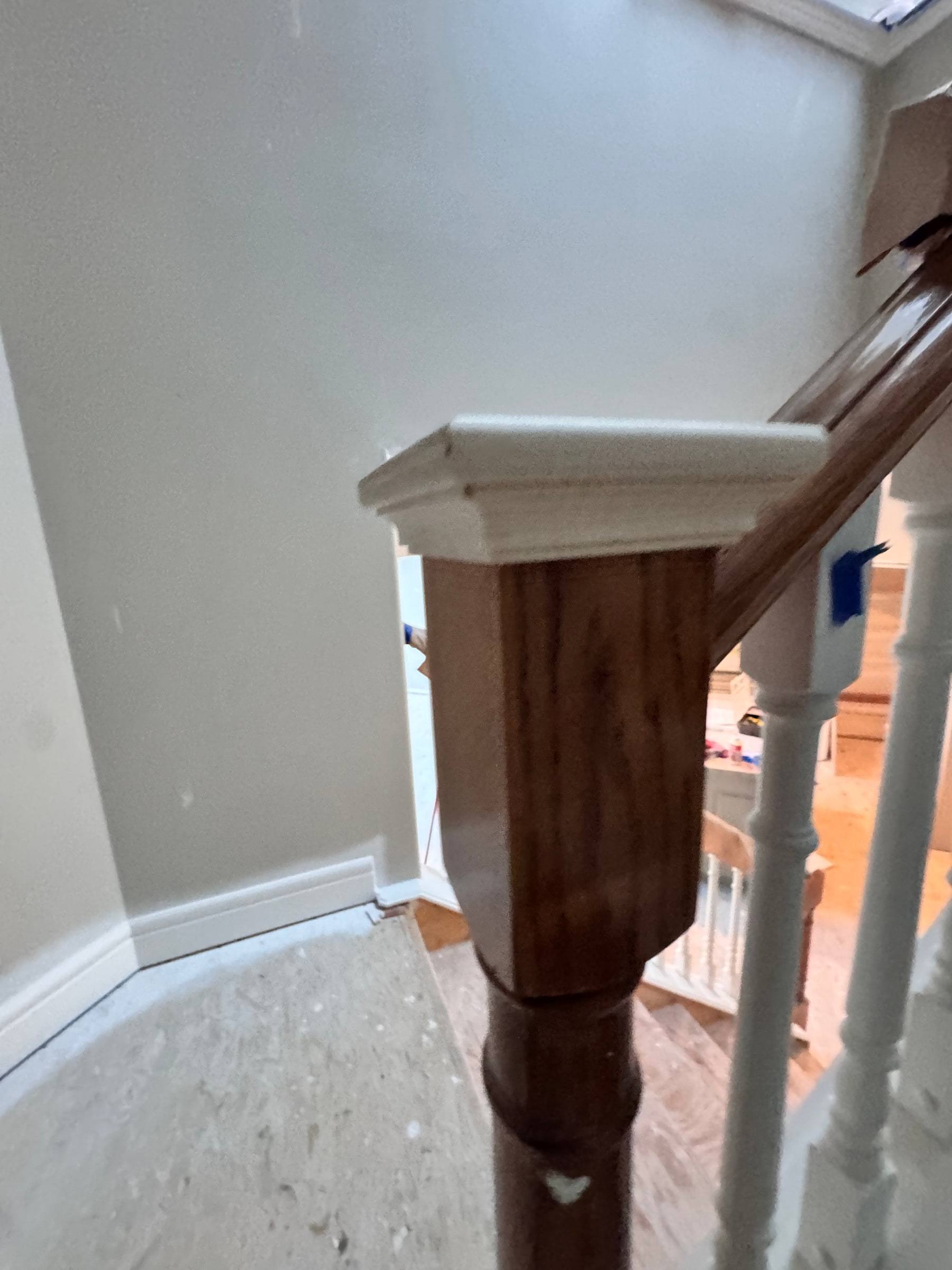 Stained newel post and railing at the top of the stairs above the main floor