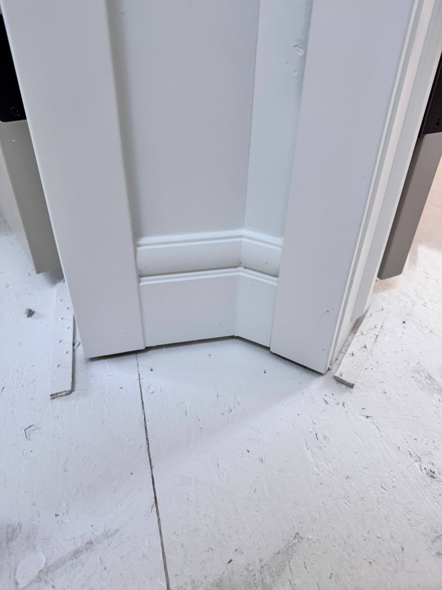 Close-up of baseboard meeting the foot of a door casing with a tight joint